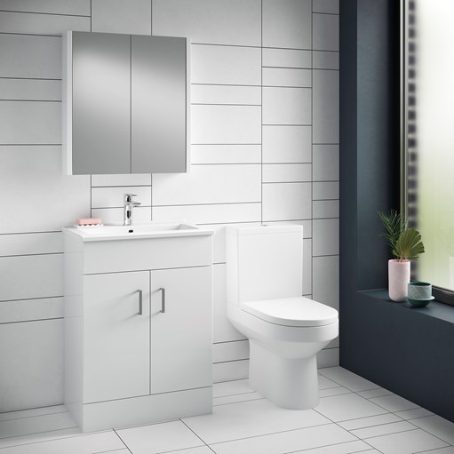 White vanity and toilet in a bright tiled bathroom